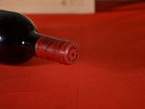 a bottle of wine sitting on a red table cloth