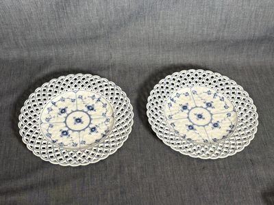a pair of blue and white doily plates on a black background