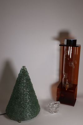 un petit sapin de Noël posé à côté d'une bouteille en verre sur une table