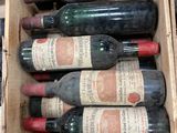 Plusieurs bouteilles de vin se trouvent dans une caisse en bois posée sur une étagère