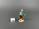 miniature figurine of a man holding a book next to a dice