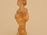 une petite figurine en verre représentant une femme avec une fleur sur la tête