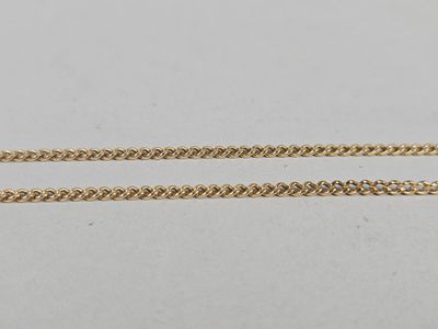 a pair of gold chains on a white surface