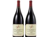 two bottles of red wine sitting next to each other on a white surface