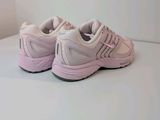 a close up of a pair of pink sneakers on a white surface