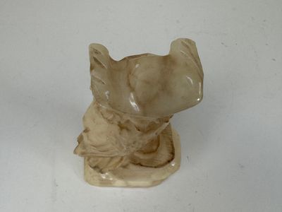 une statue de chat assise sur une surface blanche