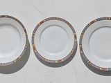 three plates with designs on them sit on a white surface