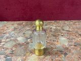 gold and glass perfume bottle on a marble table with red background