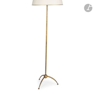 un lampadaire en laiton surmonté d'un abat-jour blanc
