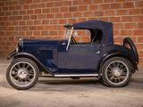 a old blue car parked in front of a brick wall
