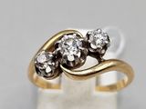 gros plan d'une bague en or ornée de trois diamants