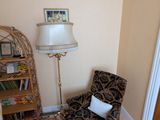 une chaise dans un coin d'une pièce où une lampe est allumée