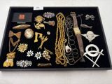 un plateau noir sur lequel sont disposés divers bijoux en or et en argent