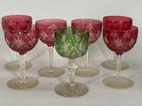 six wine glasses are lined up in a row on a white surface