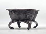a small metal bowl on a stand on a white surface