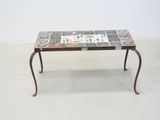 a small table with a tile top and iron legs