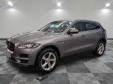 Un SUV Jaguar gris est garé dans un garage.