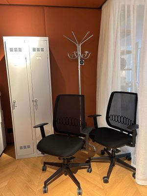 two chairs in the corner of a room with orange walls