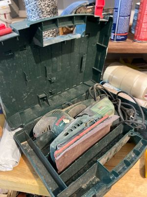 une boîte à outils contenant des outils, posée sur un établi