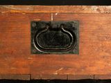 an old wooden box with a metal ring on top of it