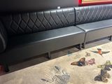 a black leather couch with a butterfly rug on the floor