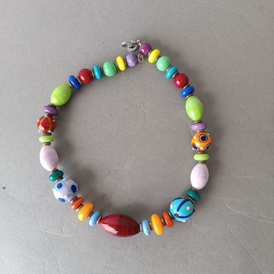 a close up of a bracelet with colorful beads on a table