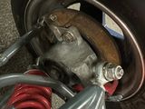 a close up view of a car ' s front wheel and suspension