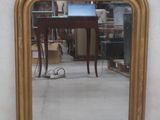a mirror on the wall reflecting a table and a chair