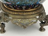 a blue and gold bowl on a stand on a white surface