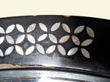 a close up of a metal plate with a flower design on it