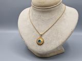 un collier en or avec un pendentif en pierre bleue sur un mannequin