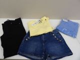 three pairs of shorts and a t - shirt sitting on a table