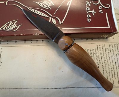 un couteau posé sur un livre, sur une table