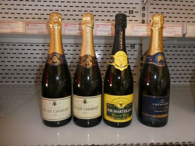 plusieurs bouteilles de vin sont alignées sur une étagère dans un magasin