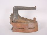 an old iron ironing device on a white surface with a white background