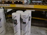 Plusieurs rouleaux de papier sont empilés les uns sur les autres dans un entrepôt