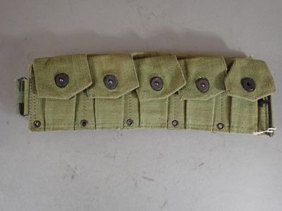 a green belt with buttons on it on a white surface