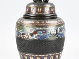 a black vase with a dog on top of it