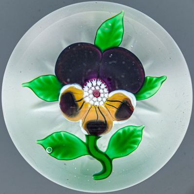 une assiette en verre ornée d'une fleur, posée sur une table