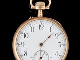 une image représentant une montre de poche en or sur fond noir