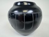 a black vase that is sitting on a table