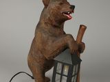 statue d'un ours tenant une batte de baseball et une maison