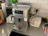 une machine à café posée sur le plan de travail de la cuisine, à côté de l'évier