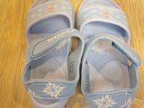 a pair of blue sandals that are on a wooden floor