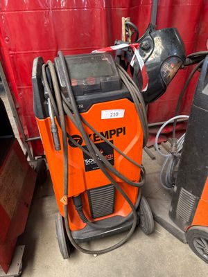 two welding machines sitting next to each other in a garage