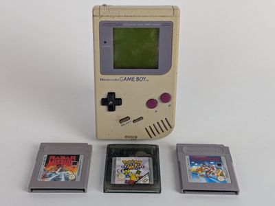 a game boy and three game cartridges next to each other