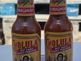 two bottles of hot sauce sitting on top of a table