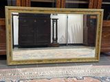 un grand miroir posé par terre devant une armoire