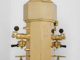 a golden machine that is sitting on a white surface