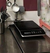 une plaque de cuisson noire posée sur un plan de travail dans une cuisine